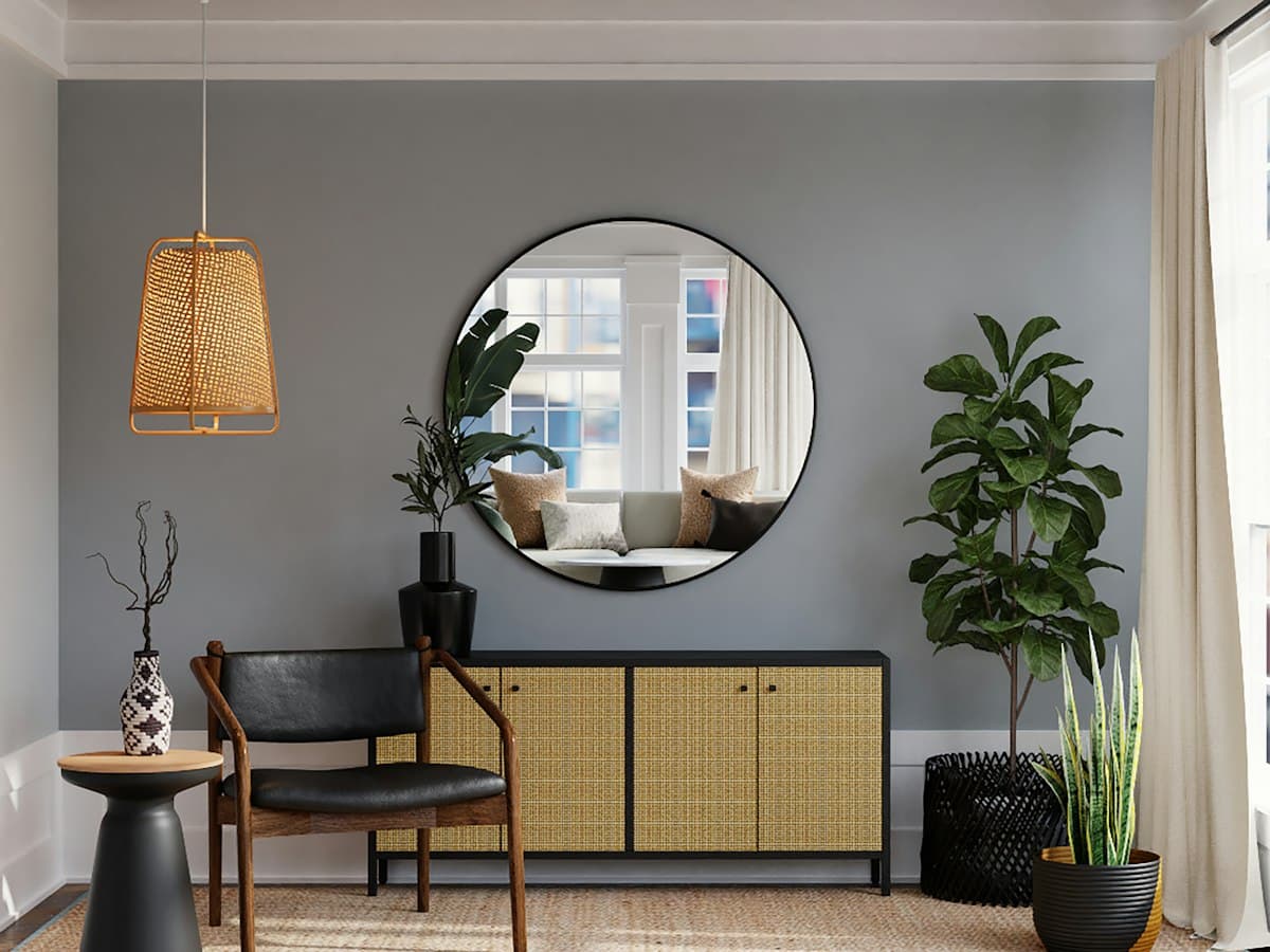 Rattan-fronted sideboard with a round mirror and warm timber accents